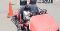 ゴーカート乗り場の前にある展示用の赤いゴーカートに乗る息子のペン太