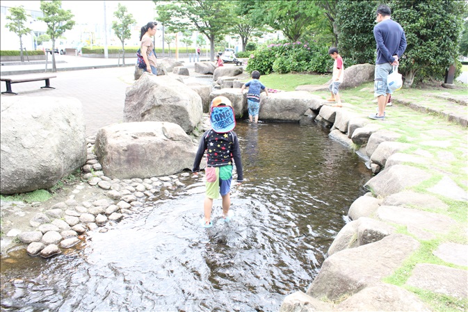 こどもたちがせせらぎで水遊びをしている様子