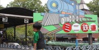 ミニ鉄道と書かれた看板の前で記念撮影
