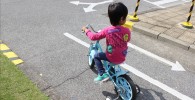 青い補助輪自転車を運転する幼児の後ろ姿
