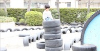 積み上げられたタイヤで遊ぶ子供